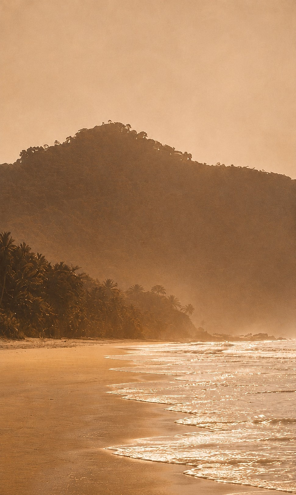 Secluded beach with mountain backdrop at sunset.