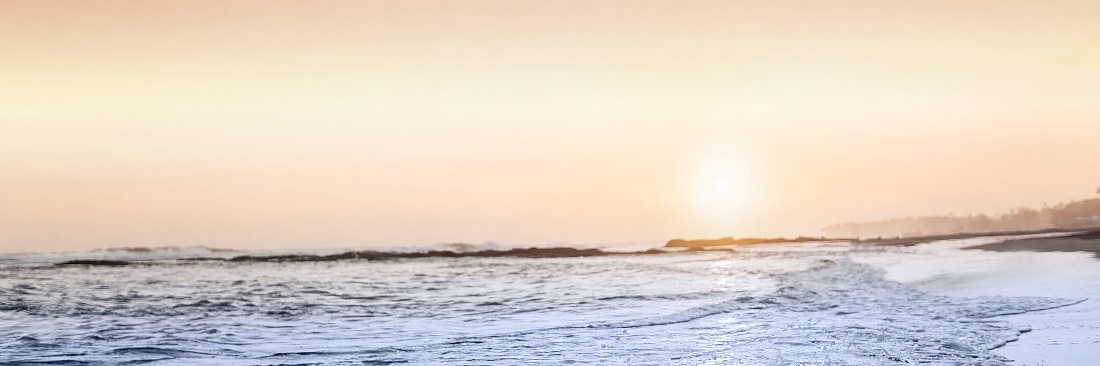 Serene beach sunset with gentle waves.